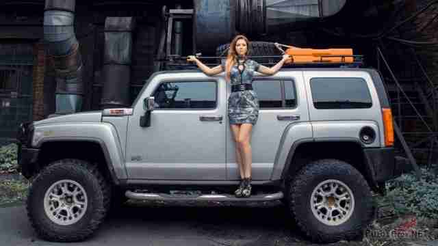 Девушка на подножке Hummer H3 на старом заводе
