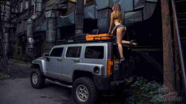 Девушка по лестнице залазит на багажник Hummer H3