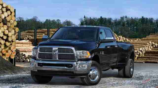 Чёрный стандартный Dodge Ram на фоне брёвен