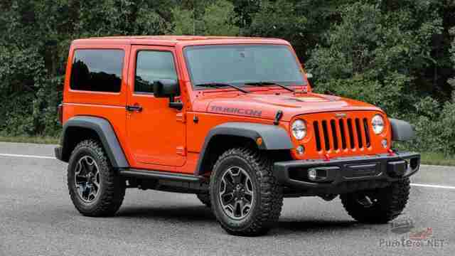 Двухдверый Jeep Wrangler на дороге у леса