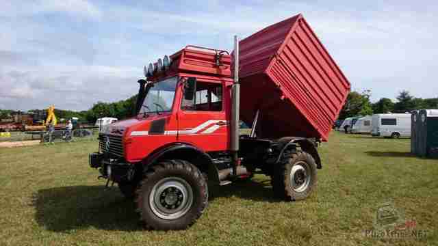 Красный Unimog с поднятым кузовом