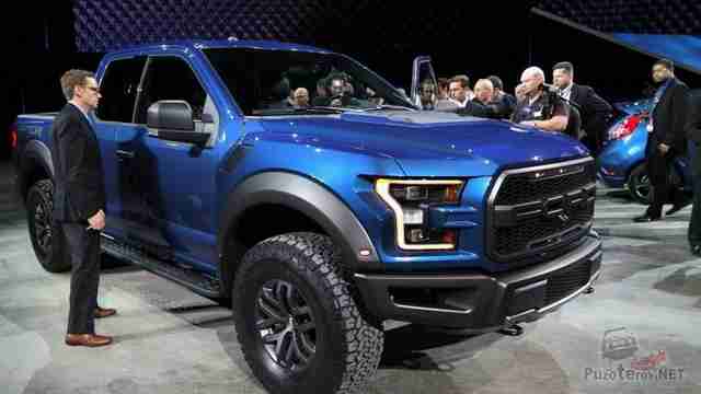 Люди рассматривают синий Ford Раптор на выставке