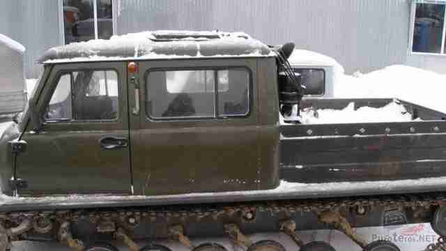Припорошенный снегом вездеход у дома