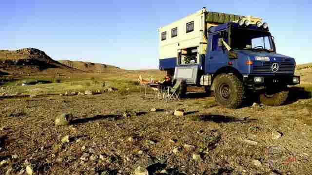 Путешественник отдыхает возле экспедиционного Mercedes-Benz Unimog