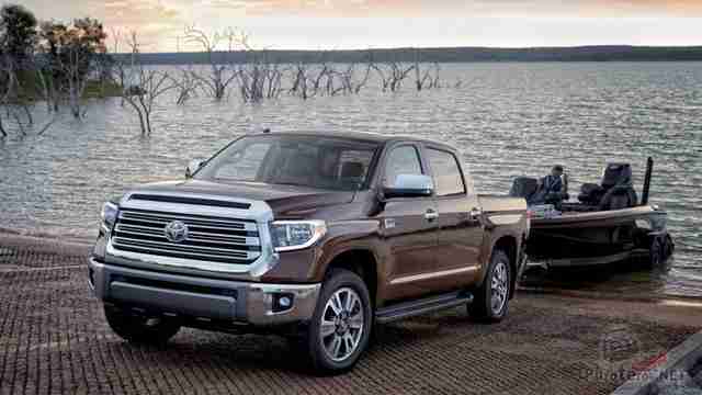 Шоколадного цвета Toyota Tundra спускает катер в озеро