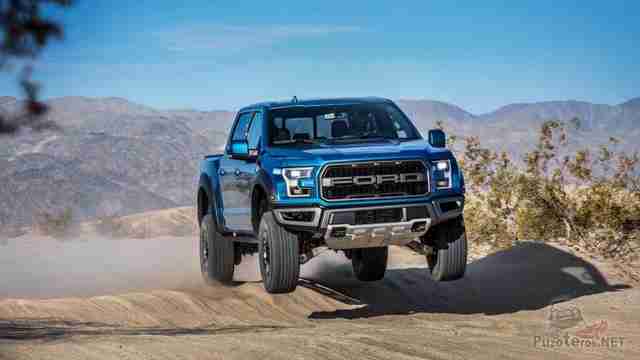 Синий Ford Раптор в прыжке с горки на дороге