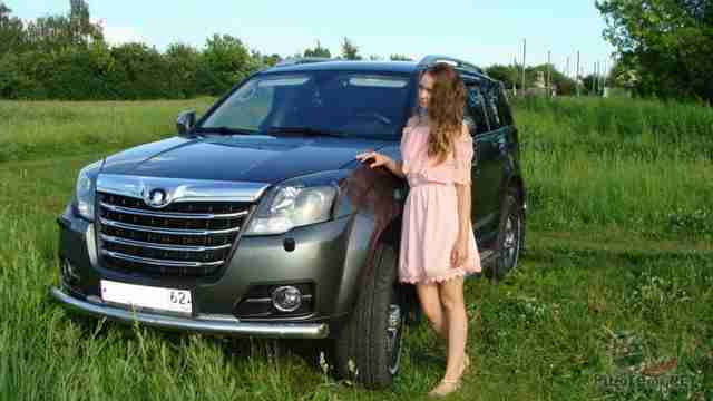 Девушка возле автомобиля на траве Девушка возле автомобиля на траве