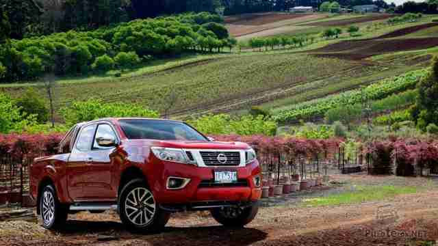 Красный Nissan Navara на фоне природы