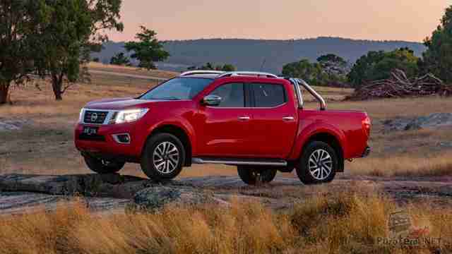 Красный Nissan Navara на камнях