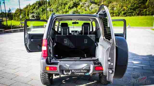 Открытые двери Suzuki Jimny на тротуаре
