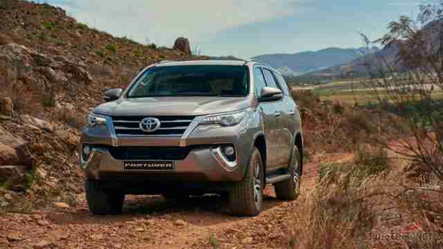 Серый Toyota Fortuner едет по дороге