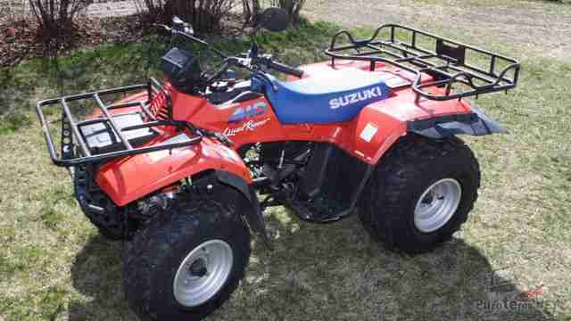 Красный Suzuki QUADRUNNER F250 на природе