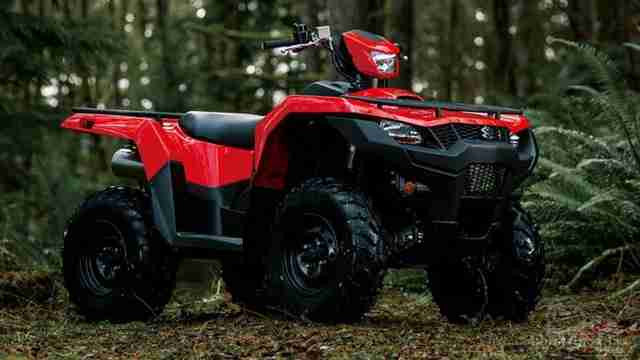 Красный квадроцикл Сузуки KingQuad 750 в лесу